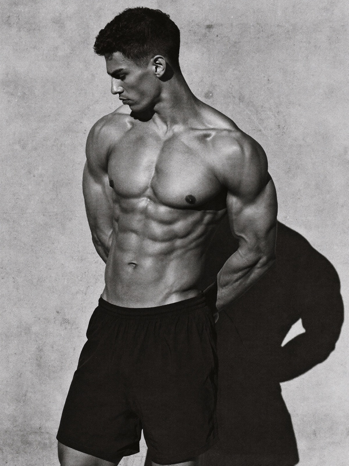 Male athlete in black shorts against concrete, shot in black and white